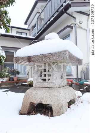 Snow-capped stone lanterns in a Japanese garden in winter Snow-capped stone lanterns in a Japanese garden in winter 137109739