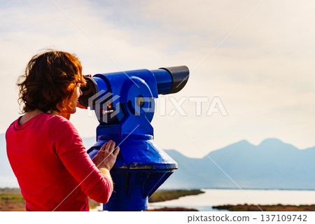 Woman using tourist binoculars, Cabo de Gata, Spain 137109742