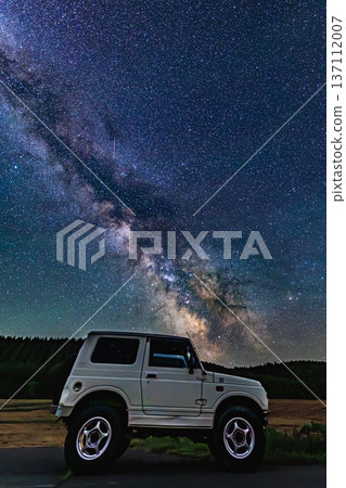 A starry sky and car light trails. The Milky Way shines brightly on the earth at night. 137112007
