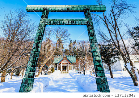 The torii gate and approach to Koshimizu Shrine covered in snow A quiet winter morning in Hokkaido 137112042