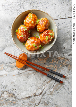 Deep fried braised tiger skin eggs with sesame and onion closeup in the bowl. Vertical top view Deep fried braised tiger skin eggs with sesame and onion closeup in the bowl. Vertical top view 137114572