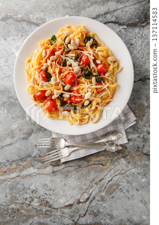 Tuscan White Bean Pasta closeup on the plate. Vertical top view 137114583