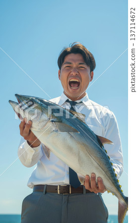 一位商人釣到了一條大魚;一位男子在海灘上歡呼雀躍 一位商人釣到了一條大魚;一位男子在海灘上歡呼雀躍 137114672