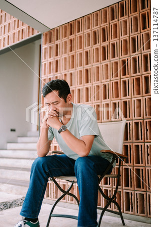 Thoughtful Man Sitting Alone, Deep in Contemplation or Worry Thoughtful Man Sitting Alone, Deep in Contemplation or Worry 137114787
