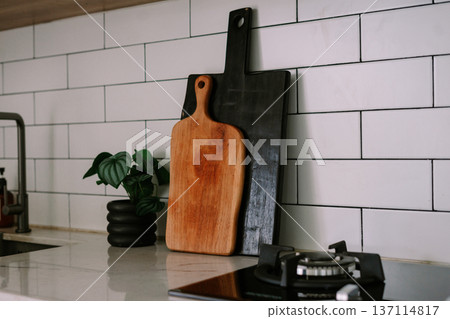 Modern Kitchen Counter with Stylish Cutting Boards and Plant Modern Kitchen Counter with Stylish Cutting Boards and Plant 137114817