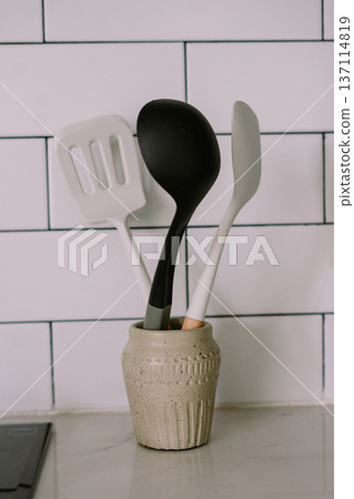 Modern Kitchen Utensils in Decorative Holder on Countertop with Subway Tiles Modern Kitchen Utensils in Decorative Holder on Countertop with Subway Tiles 137114819