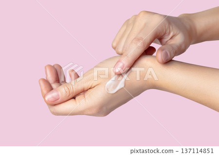 hands with swatch, smear of white cream. Face skin care, hand care, facial care. Pink cropped photo 137114851