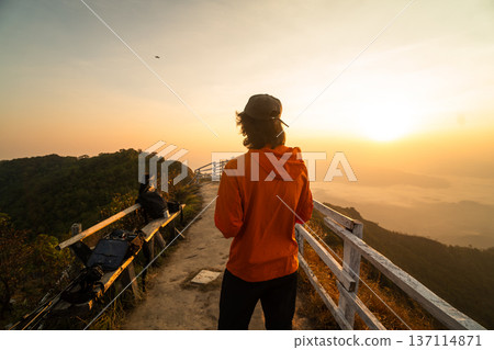 Male traveler and drone pilot operating remote controller on mountain peak during sunrise. Male traveler and drone pilot operating remote controller on mountain peak during sunrise. 137114871