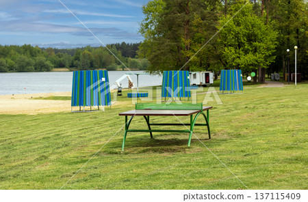A sandy path with beach grass leads through changing booths 137115409