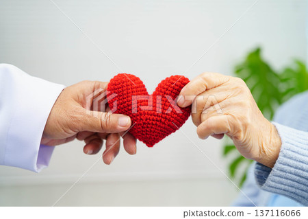 Asian elder senior woman patient holding red heart in hospital. Asian elder senior woman patient holding red heart in hospital. 137116066