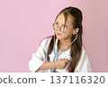 A Kid in the role of a cardiologist listens to the heartbeat of his heart using a stethoscope. Pediatrics, child health monitoring 137116320