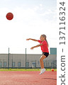 The girl throws a basketball with all her might, bouncing high.  An active team game that develops coordination and endurance 137116324