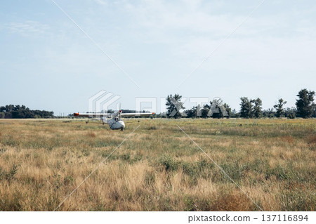 crop duster airplane rolling on dirt runway in open farmland landscape under sunlight with empty space for text panoramic banner scene concept of agribusiness, aviation, rural economy crop duster airplane rolling on dirt runway in open farmland landscape under sunlight with empty space for text panoramic banner scene concept of agribusiness, aviation, rural economy 137116894