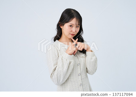 一位年輕女子用手比劃著NG手勢。 一位年輕女子用手比劃著NG手勢。 137117094