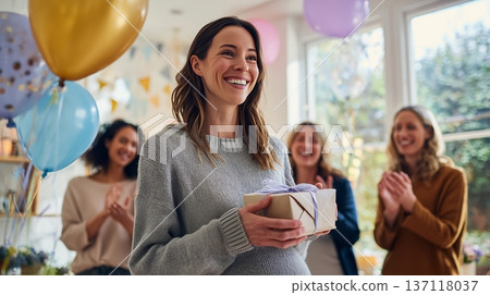 Friends celebrate with a woman holding a gift during a gender reveal party at a home on a sunny day in the afternoon Friends celebrate with a woman holding a gift during a gender reveal party at a home on a sunny day in the afternoon 137118037