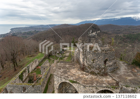 Anacopia fortress ruins with circular stone tower and arched walls overlooking Black Sea coastline and mountain valley in Abkhazia, Historic architecture and panoramic landscape ideal for tourism Anacopia fortress ruins with circular stone tower and arched walls overlooking Black Sea coastline and mountain valley in Abkhazia, Historic architecture and panoramic landscape ideal for tourism 137118602