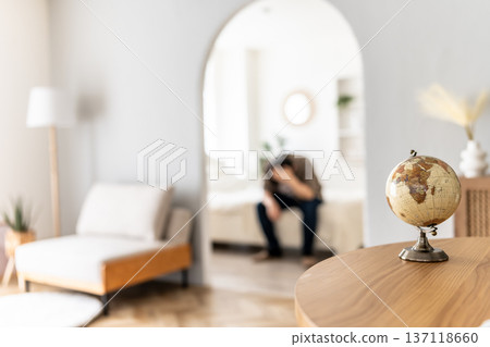 A worried person in a room and a globe A worried person in a room and a globe 137118660