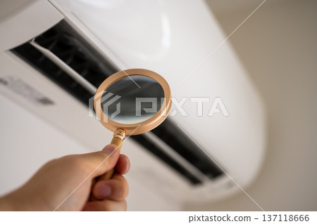 Check the inside of the air conditioner with a magnifying glass Check the inside of the air conditioner with a magnifying glass 137118666