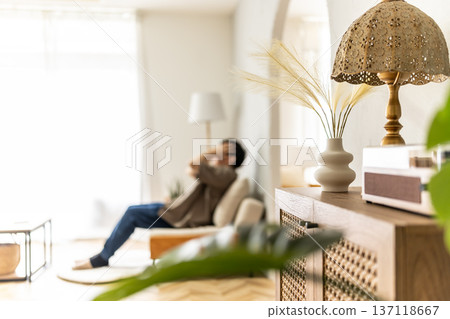 A man holding his head in the living room 137118667