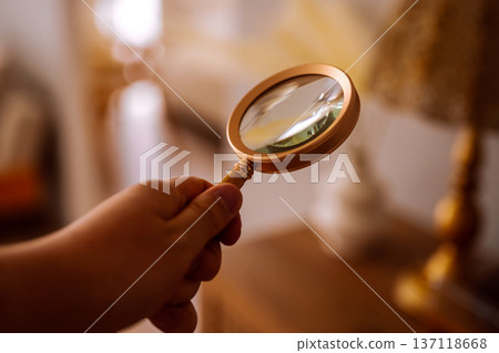 Hand examining details with a magnifying glass 137118668