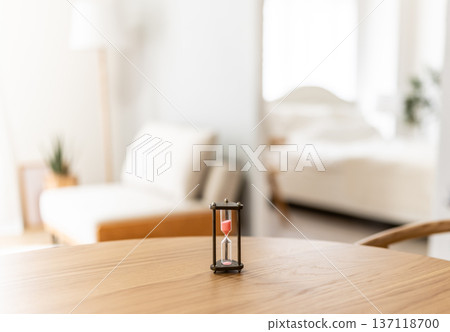 Hourglass on the desk in the room 137118700