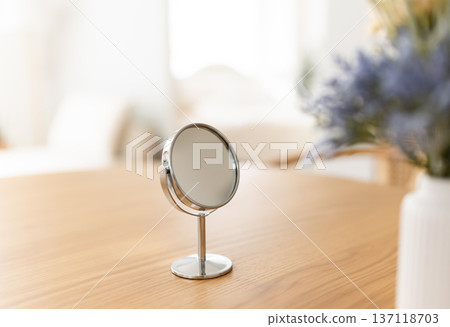 A circular mirror placed on a table A circular mirror placed on a table 137118703