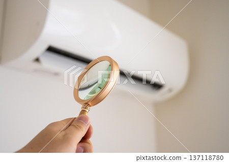 Inspect the air conditioner with a magnifying glass Inspect the air conditioner with a magnifying glass 137118780