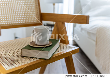 A book and a mug on a chair 137118818