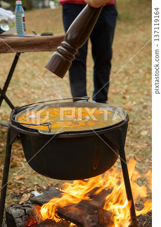 Seasoning fish soup in outdoor cauldron Seasoning fish soup in outdoor cauldron 137119164