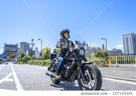 A female rider touring Yokohama on a cruiser bike 137119391