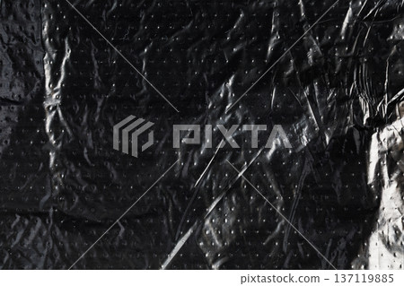 Black crumpled plastic bag wrapping abstract texture background Black crumpled plastic bag wrapping abstract texture background 137119885
