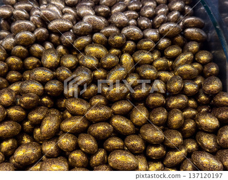 Chocolate glazed nuts filling the entire frame in Istanbul bazaar. Texture focus, indulgent mood, sensory depth, and tactile appeal in confectionery detail. 137120197