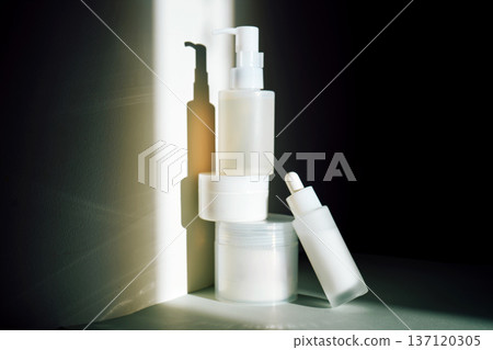 Skincare product bottles creating shadows on minimalist background Skincare product bottles creating shadows on minimalist background 137120305