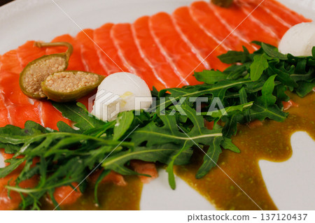 A plate with sliced red fish, bread and greens A plate with sliced red fish, bread and greens 137120437