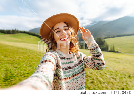 Close-up of a happy woman taking a selfie while hiking. Nature, adventure concept. Active lifestyle. 137120458