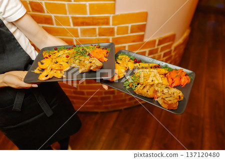 Delicious dishes on plates in the waiter's hand 137120480