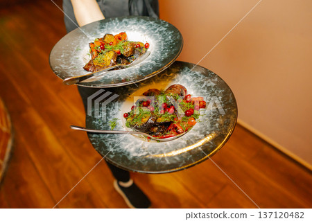 Delicious dishes on plates in the waiter's hand 137120482