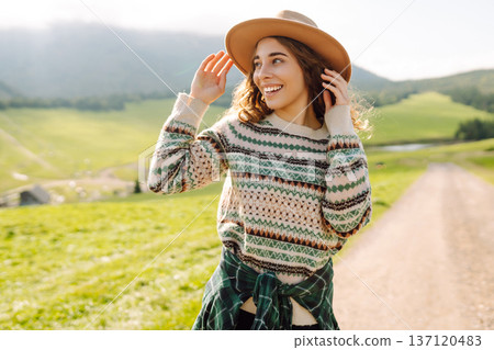 Happy female traveler exploring area in green valley with mountains in background. Concept of nature Happy female traveler exploring area in green valley with mountains in background. Concept of nature 137120483