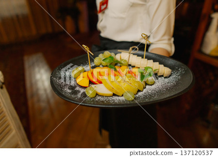 Delicious dishes on plates in the waiter's hand Delicious dishes on plates in the waiter's hand 137120537