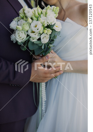 The bride and groom are holding a wedding bouquet The bride and groom are holding a wedding bouquet 137120543