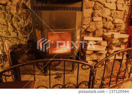 A burning iron fireplace in a cozy cafe A burning iron fireplace in a cozy cafe 137120564