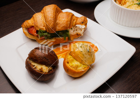 Croissant with salmon and stuffed buns on a plate Croissant with salmon and stuffed buns on a plate 137120597