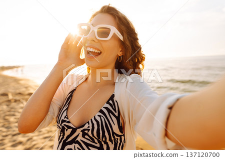 Portrait of young woman using smart phone selfie live on the beach. Technology connected. Portrait of young woman using smart phone selfie live on the beach. Technology connected. 137120700