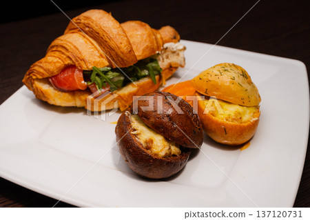 Croissant with salmon and stuffed buns on a plate Croissant with salmon and stuffed buns on a plate 137120731