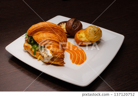 Croissant with salmon and stuffed buns on a plate 137120752