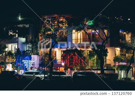 Luxury modern villa exterior with decorative lighting and tropical garden at night, Elegant contemporary residence facade illuminated with plants and night architectural lights 137120760