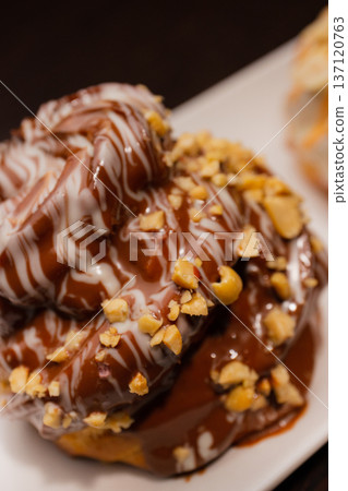 Cinnabon on a white plate and on a wooden table 137120763