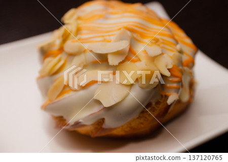 Cinnabon on a white plate and on a wooden table 137120765