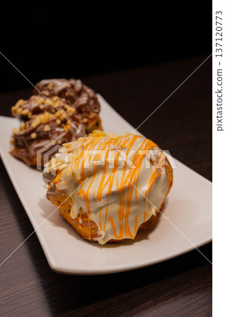 Cinnabon on a white plate and on a wooden table 137120773
