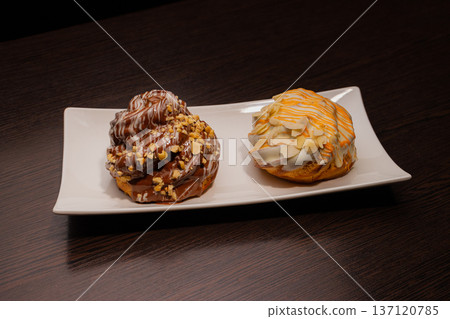 Cinnabon on a white plate and on a wooden table 137120785